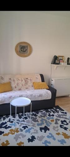 un salon avec un lit et une table dans l'établissement Agréable 2 pièces - rue du vieux Versailles, à Versailles