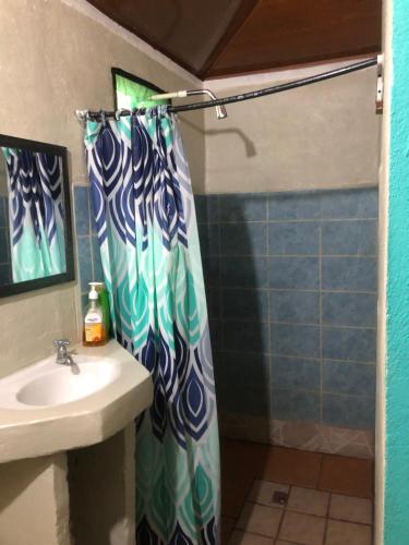 a shower curtain in a bathroom with a sink at CABINA EL MANU in Golfito