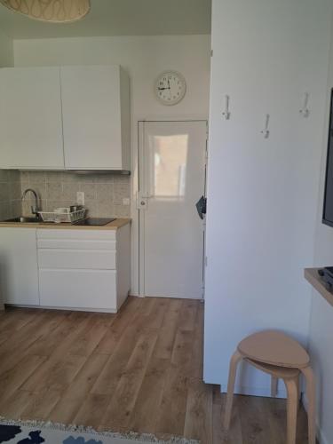 a kitchen with white cabinets and a table and a stool at Agréable 2 pièces - rue du vieux Versailles in Versailles