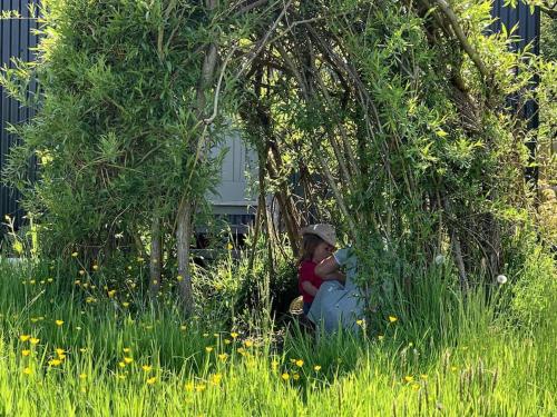 a person sitting in the grass under a tree at Rushford Shepherd's Hut in Newton Abbot