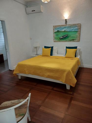 a bedroom with a large bed with a yellow blanket at Explora Prestige in Blue Bay