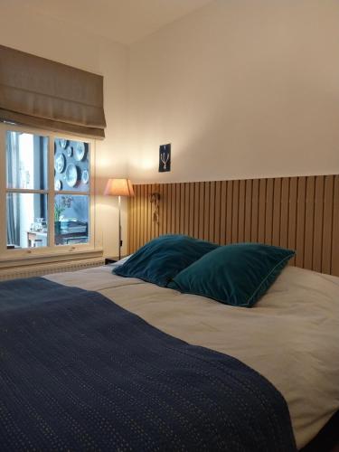 een slaapkamer met een groot bed en een raam bij B&B Noordwijk Binnen in Noordwijk