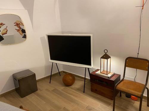 - un salon avec une télévision à écran plat et une chaise dans l'établissement Vicolo Rosso 2, à Dolceacqua