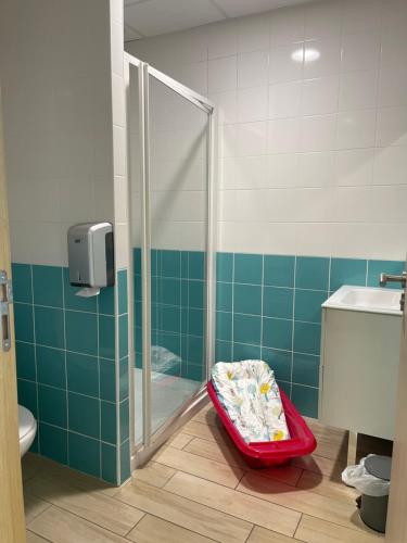 La salle de bains est pourvue d'une douche et d'un plateau rouge. dans l'établissement CLLCM - Club Leo Lagrange de Camaret-sur-Mer, à Camaret-sur-Mer