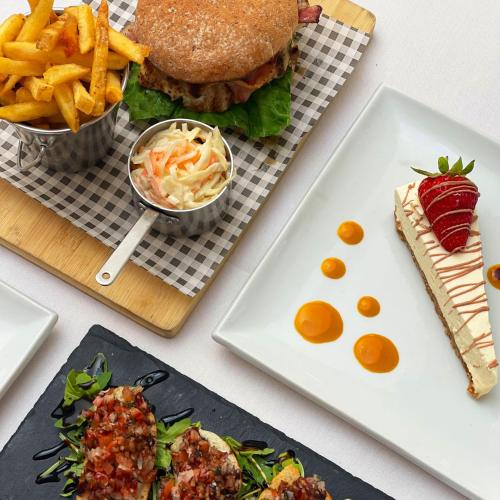 a table with plates of food and a sandwich and fries at Dalmeny Hotel in Lytham St Annes