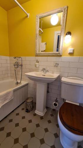 uma casa de banho com um lavatório, um WC e um espelho. em Lahe Guesthouse em Haapsalu