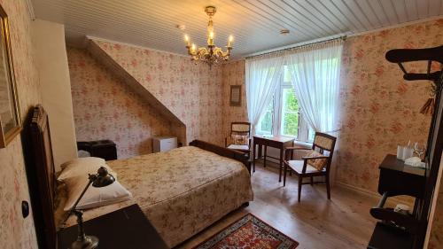 a bedroom with a bed and a chandelier at Lahe Guesthouse in Haapsalu