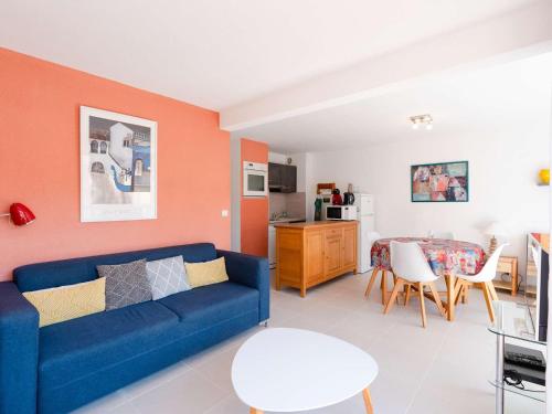 un salon avec un canapé bleu et une table dans l'établissement Appartement T2 climatisé avec balcon, parking privé, 4 couchages, centre Narbonne-Plage, proche mer - FR-1-409-65, à Narbonne