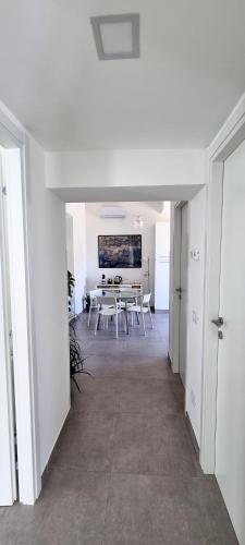 Habitación blanca con mesa y sillas. en Il Melograno, en Guidonia