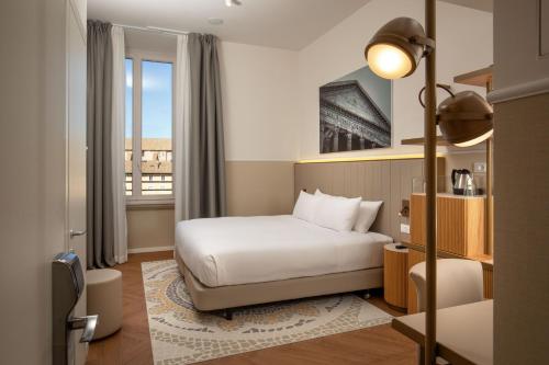 a hotel room with a bed and a window at Cosmopolita Hotel Rome, Tapestry Collection by Hilton in Rome