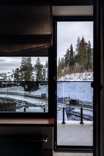 a window with a view of a snow covered field at Ribas Karpaty in Bukovel