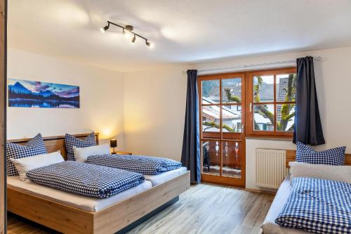 een slaapkamer met 2 bedden en een raam bij Ferienwohnung Zugspitze in Farchant
