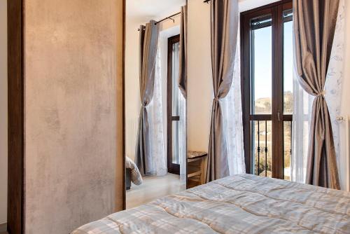 um quarto com uma cama e uma grande janela em Ca ed Giuanoto em Santo Stefano Belbo
