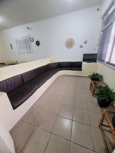 a living room with a couch in the corner at Guarujá Praia Hotel Econômico in Guarujá