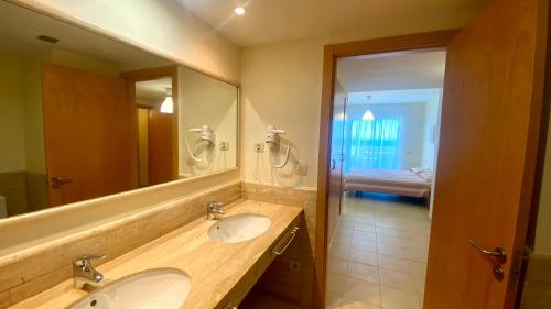 a bathroom with two sinks and a large mirror at Residencial Marina de Port in L'Ametlla de Mar