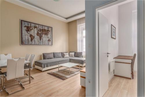 Heart of Buda Apartments في بودابست: غرفة معيشة مع أريكة وطاولة