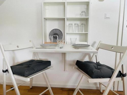 a white table and two chairs in a room at Dachstudio Eggingen in Eggingen