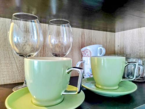 a table with two coffee cups and wine glasses at Le Petit Studio in Kanarevo Brdo