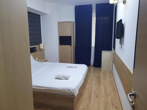 um quarto com uma cama branca e piso em madeira em MARCY APARTAMENT em Bucareste