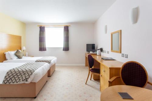 a hotel room with two beds and a desk at George Albert Hotel & Spa in Dorchester