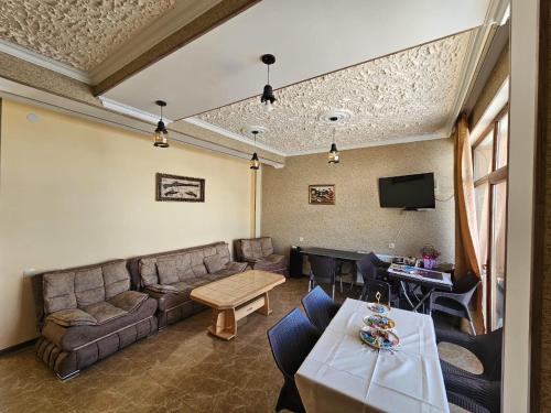 a living room with a couch and a table at DISCOVER KAZBEGi HOTEL in Kazbegi
