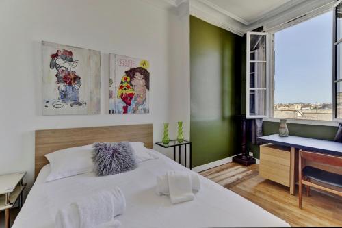 um quarto com uma grande cama branca e uma secretária em LE VICTOR - Grand et lumineux T3 em Bordeaux