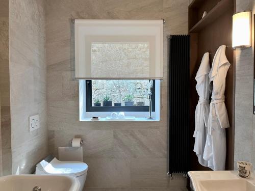 a bathroom with a toilet and a window at The Iconic Lodge in Bellagio