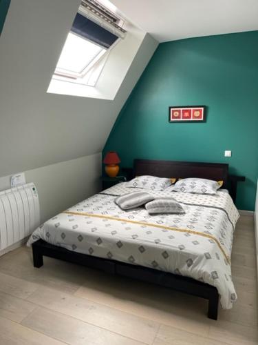 a bedroom with a bed with a blue wall at La Grange du Pont in Civray-de-Touraine