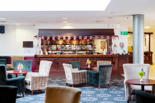 a restaurant with tables and chairs and a bar at George Albert Hotel & Spa in Dorchester