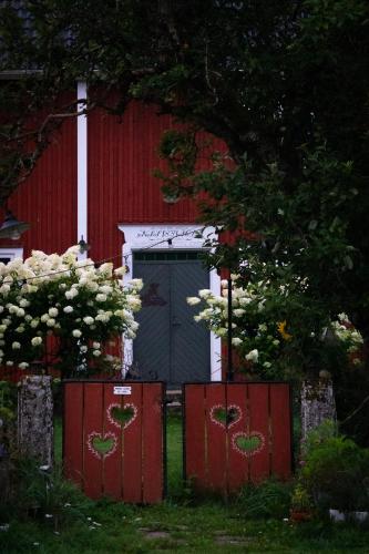 a red shed with a blue door in front of it at La Maison Rouge de Slätten Bed and Breakfast in Vilshult