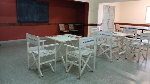 una clase con mesas y sillas blancas y una pizarra en Alojamiento en pleno centro de Corrientes en Corrientes