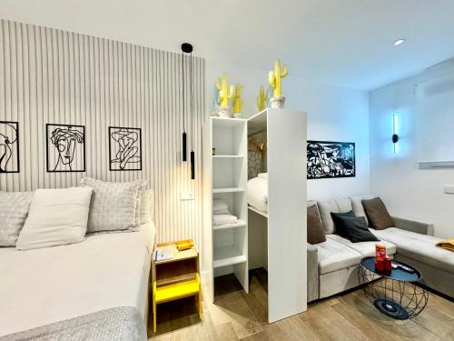 a bedroom with a white bed and a couch at Luxury private Flat City Center, AC & Parking gratuito in Madrid
