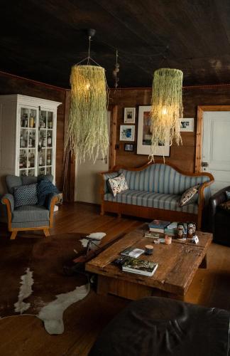 a living room with a couch and a table at La Maison Rouge de Slätten Bed and Breakfast in Vilshult