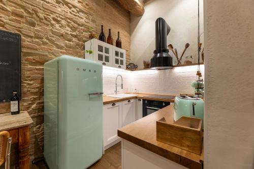 a kitchen with a green refrigerator and a brick wall at Al 24 Rosso in Siena