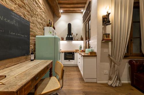 a kitchen with a wooden table and a refrigerator at Al 24 Rosso in Siena