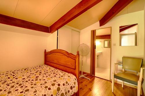 une chambre avec un lit, une chaise et un miroir dans l'établissement Appartement n1 rez de jardin LA LISCIA, à Calcatoggio