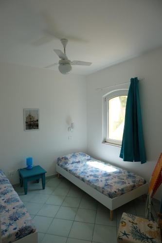 ein Zimmer mit zwei Betten und einem Fenster in der Unterkunft Calarossa Sardinia Apartments in Isola Rossa