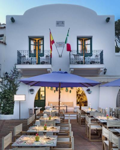 a restaurant with tables and umbrellas in front of a building at Boutique Hotel Solaz in Porto Rafael