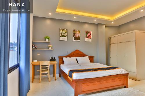 a bedroom with a bed and a table with a chair at S79 Light House Condo Hotel Hanoi in Hanoi
