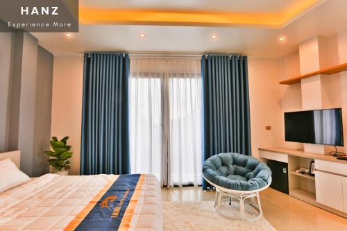 a bedroom with a bed and a chair and a television at S79 Light House Condo Hotel Hanoi in Hanoi