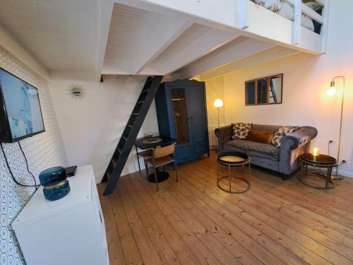 a living room with a couch and a loft at Les Appartements du 104 in Saint-Jean-de-Monts