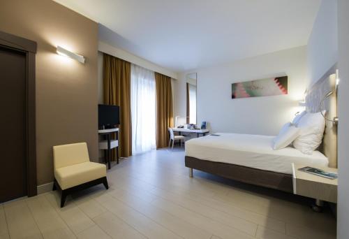 una camera d'albergo con letto e sedia di Pullman Almar Timi Ama Resort & Spa a Villasimius