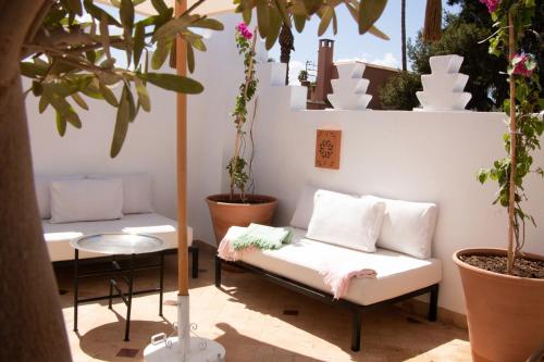 a patio with a couch and a table and potted plants at Riad Sashema in Marrakesh