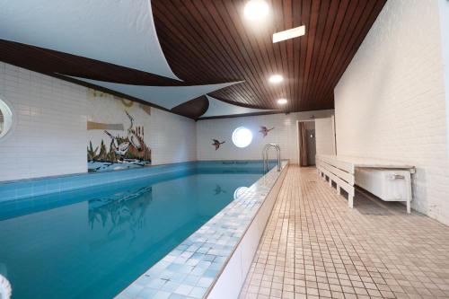 a large swimming pool in a building with a large swimming pool at Ferienhaus II Blumenwiese in Schwienkuhl an der Ostsee-für 10 Pers Sauna-Whirlwanne Ostsee in Schwienkuhl