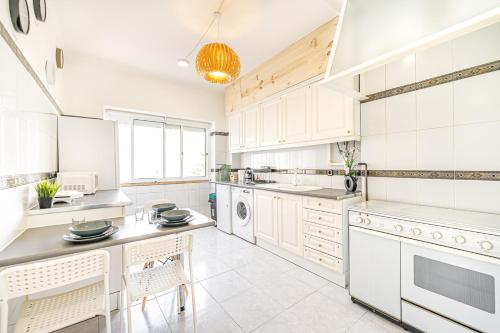 a kitchen with white cabinets and white appliances at Goa Square by Lisbon with Sintra in Amadora