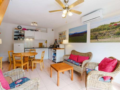 une cuisine et un salon avec une table et des chaises dans l'établissement Charmante Villa Climatisée à Narbonne-Plage, Proche Mer, 6 Personnes, 3 Chambres, Parking Privé - FR-1-409-120, à Narbonne-Plage
