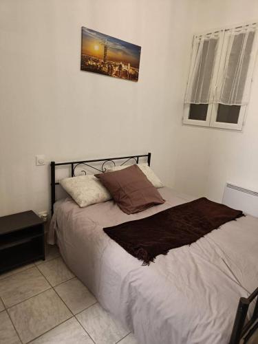 uma cama num quarto com uma fotografia na parede em BEAU SOLEIL em Amélie-les-Bains-Palalda