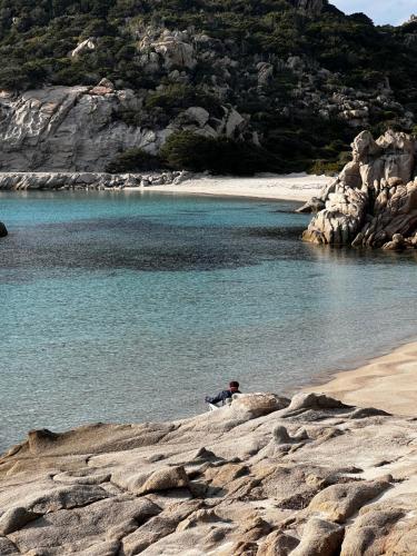 a person sitting on the shore of a beach at Boutique Hotel Solaz in Porto Rafael