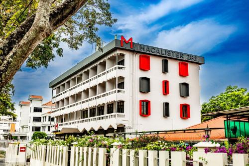 a white building with red windows and a sign on it at Macalister 288 in George Town