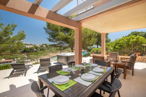 een patio met een tafel en stoelen bij Cala Mendia Beach House 1 by Slow Villas in Cala Romantica